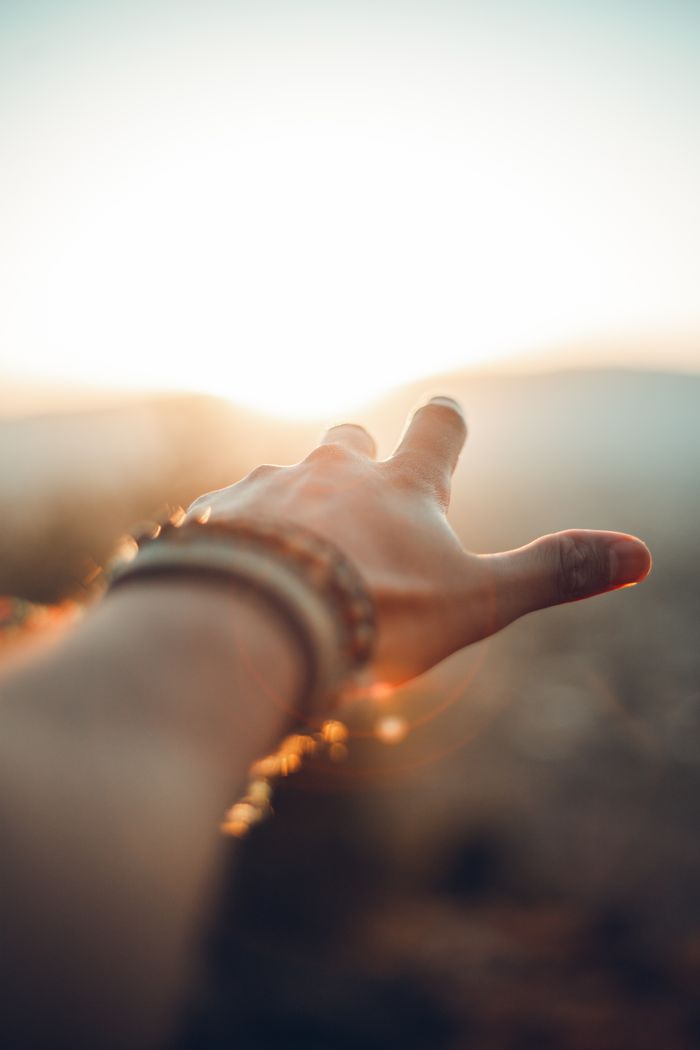 services-07 A hand adorned with bracelets reaching towards the sunlight in Beirut, capturing a vibrant moment.