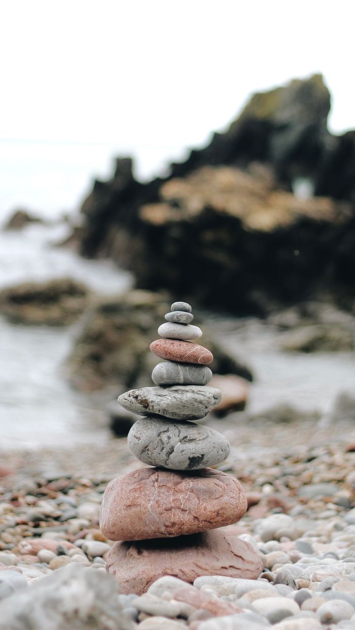 Tranquil stacked stones on a rocky beach, symbolizing balance and calm.